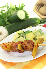 Image showing Potato-cucumber salad with fire skewers and chilli