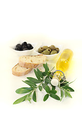 Image showing Bottle of olive oil with olives and branch