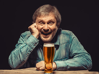 Image showing The smiling man in denim shirt with glass of beer