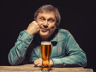 Image showing The satisfied man in denim shirt with glass of beer