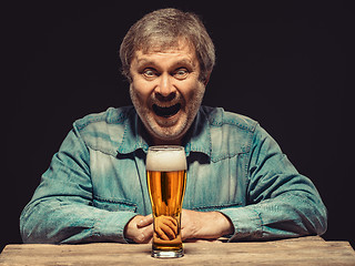 Image showing The smiling man in denim shirt with glass of beer