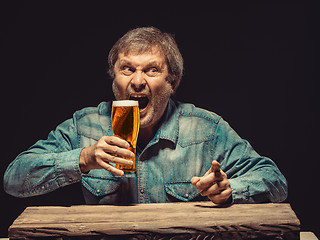 Image showing The screaming man in denim shirt with glass of beer