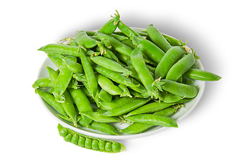 Image showing Opening and closing pea pods on white plate top view