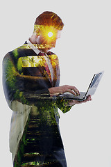 Image showing double exposure of business man who working on laptop and alley 