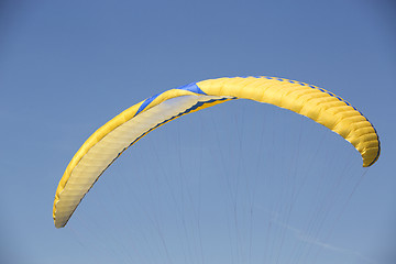 Image showing Yellow paraglider with blue sky