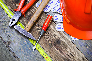 Image showing Vintage hammer, pliers, screwdriver, tape measure, a bright helm