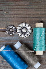 Image showing two vintage buttons flowers and spools with threads