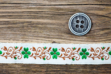 Image showing vintage band with embroidered ornaments and old button