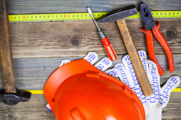 Image showing Vintage hammer, pliers, screwdriver, tape measure, a bright helm