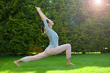 Image showing pretty adult woman doing yoga on grass