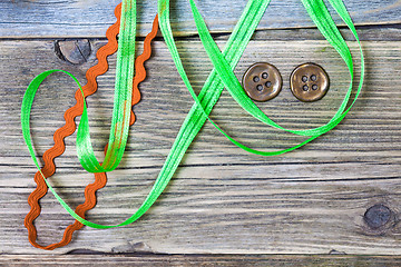 Image showing still life with old green and red tapes and two vintage buttons