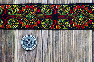 Image showing old band with embroidered ornaments and vintage button