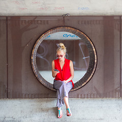 Image showing Young cheerful woman using smarthphone.