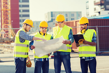 Image showing group of builders with tablet pc and blueprint