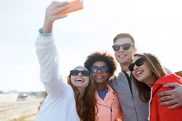 Image showing smiling friends taking selfie with smartphone