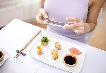 Image showing woman with smartphone taking picture at restaurant