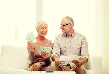 Image showing senior couple with money and calculator at home