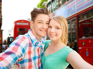 Image showing happy couple taking selfie over london city