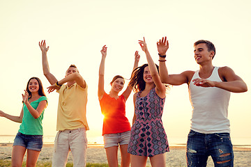 Image showing smiling friends dancing on summer beach