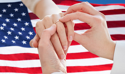 Image showing close up of lesbian couple hands with wedding ring