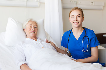 Image showing doctor or nurse visiting senior woman at hospital