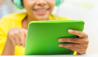 Image showing happy african woman with tablet pc and headphones