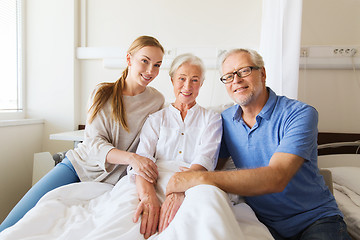 Image showing happy family visiting senior woman at hospital