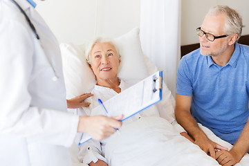 Image showing senior woman and doctor with clipboard at hospital