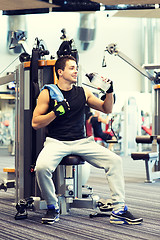 Image showing smiling man exercising on gym machine