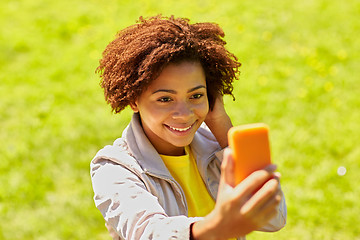 Image showing happy african woman taking selfie with smartphone