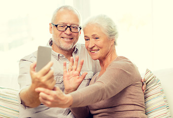 Image showing happy senior couple with smartphone at home