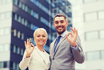 Image showing smiling businessmen standing over office building