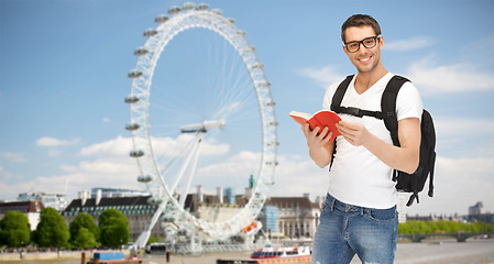 Image showing happy young man with backpack and book travelling