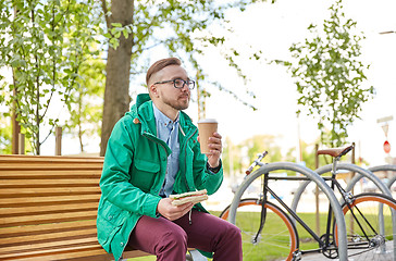 Image showing happy young hipster man with coffee and sandwich