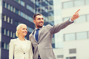 Image showing smiling businessmen standing over office building