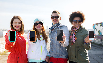 Image showing smiling friends showing blank smartphone screens