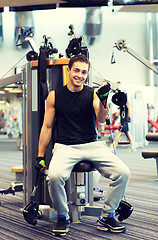 Image showing smiling man exercising on gym machine