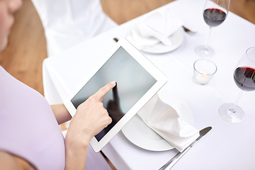 Image showing close up of woman with tablet pc at restaurant