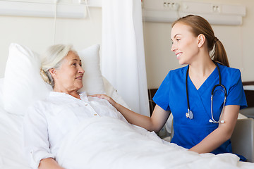 Image showing doctor or nurse visiting senior woman at hospital