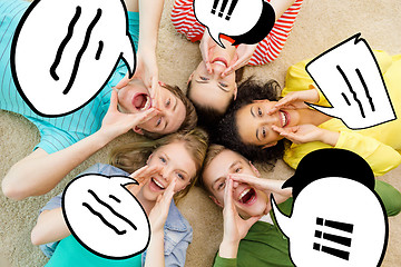 Image showing smiling people lying down on floor and screaming