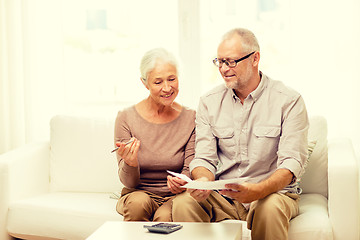 Image showing senior couple with papers and calculator at home