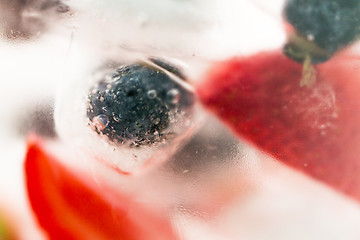 Image showing close up of fruit water with ice cubes over glass