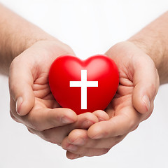 Image showing male hands holding heart with cross symbol