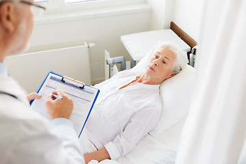 Image showing senior woman and doctor with clipboard at hospital