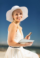 Image showing woman in hat doing online shopping outdoors