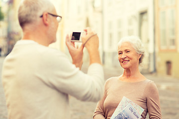 Image showing senior couple photographing on city street