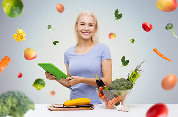 Image showing smiling woman with tablet pc cooking vegetables