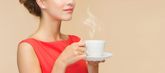 Image showing smiling woman in red dress with cup of coffee