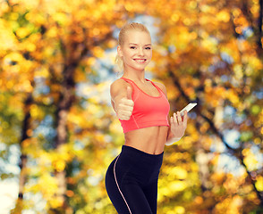 Image showing smiling sporty woman with smartphone