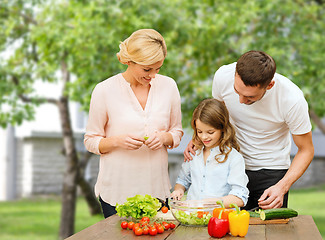 Image showing happy family cooking vegetable salad for dinner